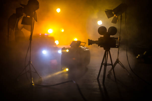 Action movie concept. Police cars and miniature movie set on dark toned background with fog. Police car chasing a car at night. Scene of crime accident. Selective focus